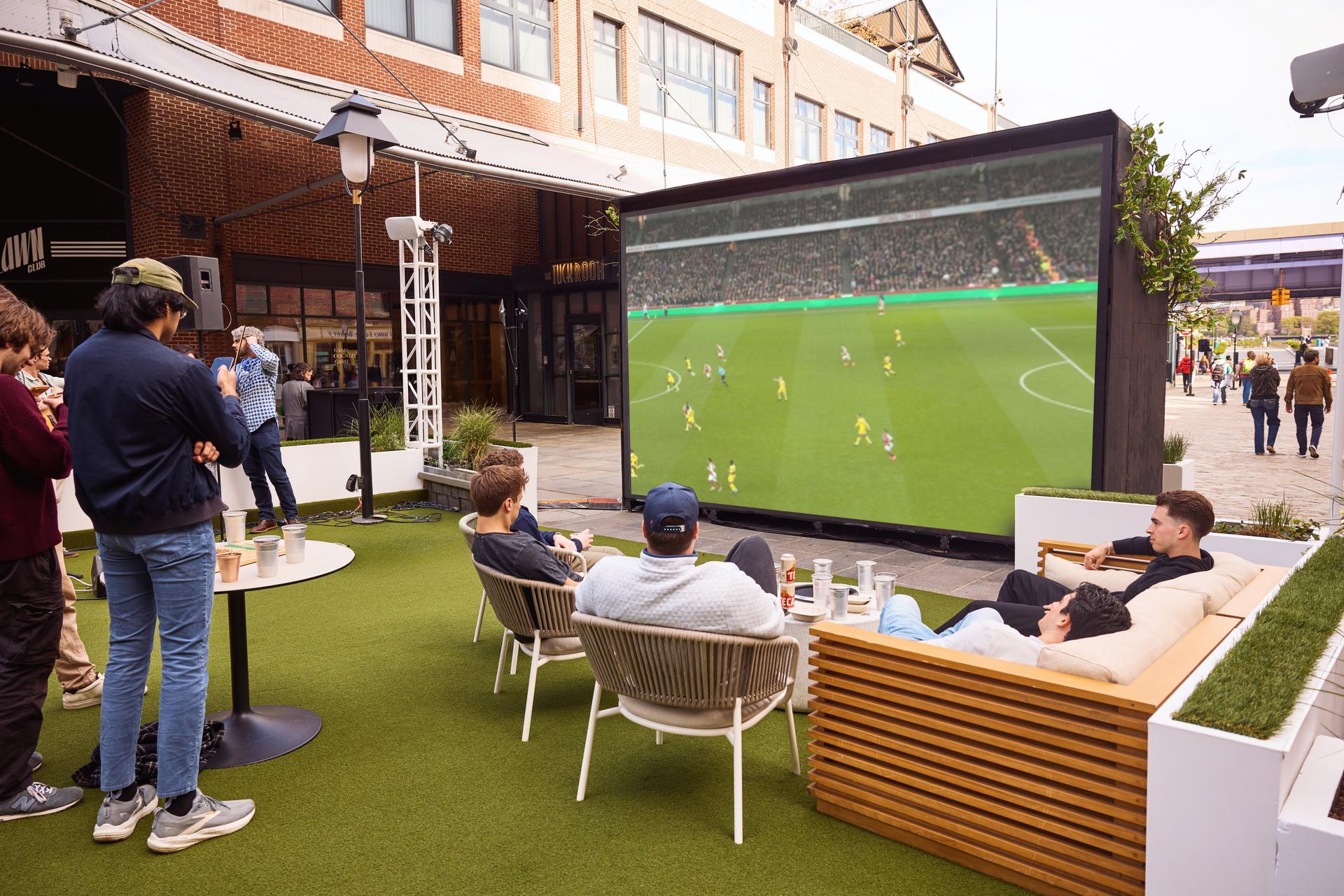 a group of young men watch the World Cup at Sadie's Garden Bar's 18 foot outdoor screen